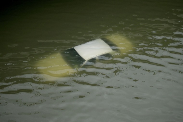 Image: A car is submerged on a freeway flooded by Tropical Storm Harvey