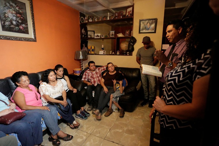 Image: Evangelical preacher talks to relatives of the Saldivar family, whose van was reportedly carrying six family members when it was swept away by floodwaters from Hurricane Harvey, at their house in Monterrey