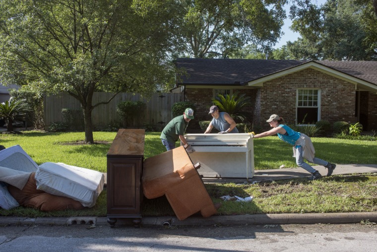 Image: Friends band together to help Scott Hausman-Weiss remove damp sheet-rock, waterlogged floors, and ruined possessions from his home on Braesvalley Drive, Houston, after it flooded during Hurricane Harvey.