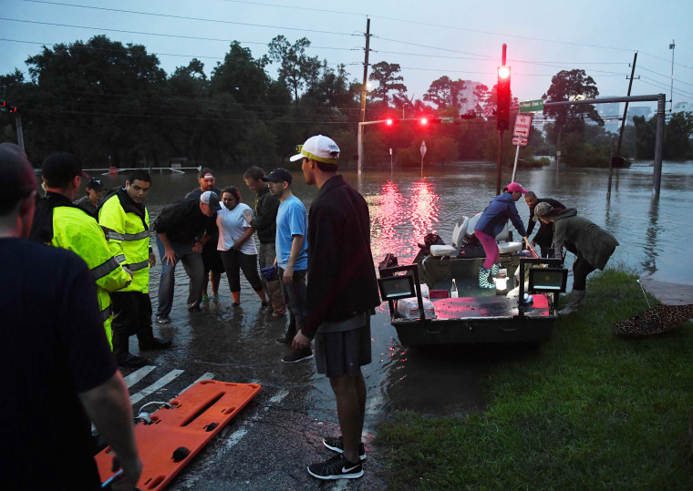 Image: A woman with a back injury receives medical treatment after being rescued by boat after Hurricane Harvey