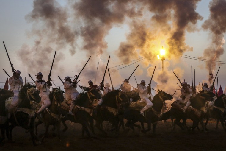 Image: Horse riders fire their gunpowder filled rifles as they take part in Tabourida