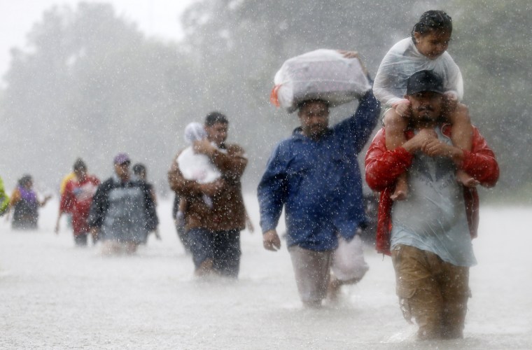 Image: Residents wade through flood waters from Tropical Storm Harvey in Beaumont Place, Houston