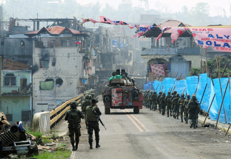 Image: Government troops march towards the Mapandi bridge during a battle against insurgents