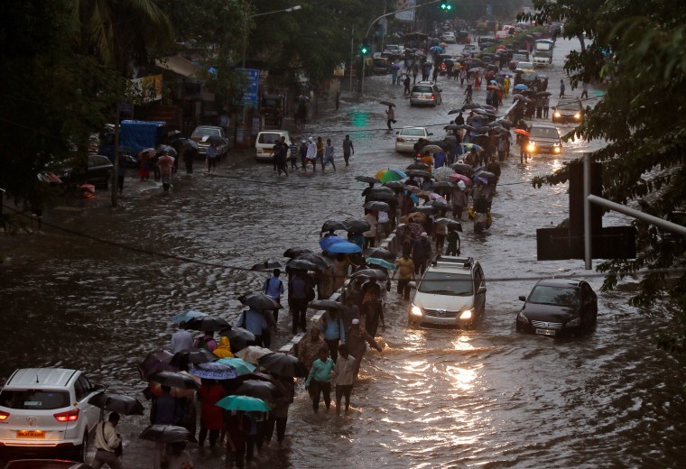 Image: Commuters walk through water-logged roads after rains in Mumbai