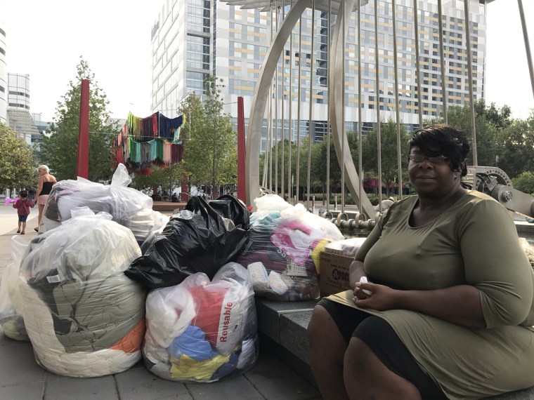Image: Quajhonita Martin, 31, sits outside the George R. Brown convention center in downtown Houston with her belongings packed to stay with a relative until she can find a job, Sept. 1, 2017.