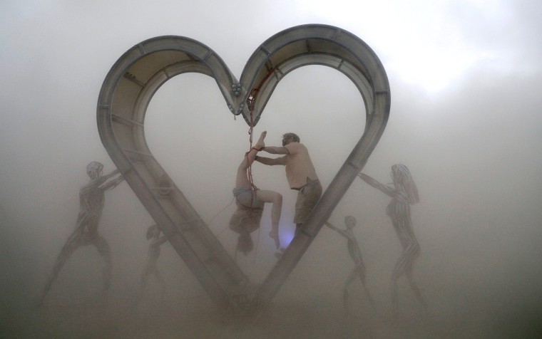 Image: Burning Man participants perform a shibari rope scene during desert dust storm at the Burning Man festival in the Black Rock Desert of Nevada