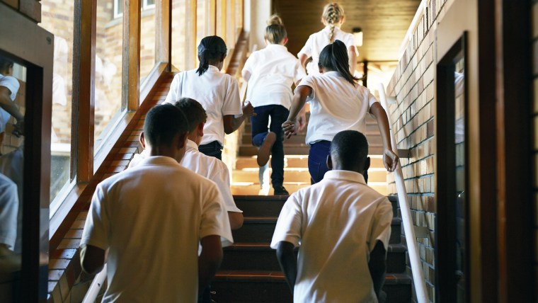 Young students running up stairs at the school