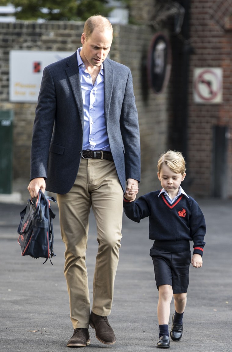 Britain's Prince George accompanied by Britain's Prince William (L), Duke of Cambridge arrives for his first day of school.