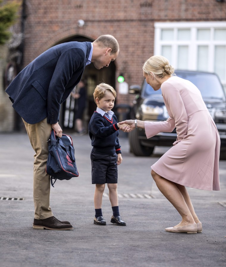 Britain's Prince George accompanied by Britain's Prince William (L), Duke of Cambridge arrives for his first day of school.