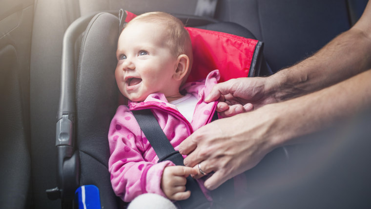 Little baby girl in a car in a child seat