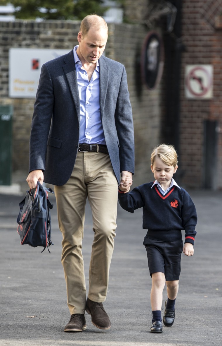 Britain's Prince George accompanied by Britain's Prince William (L), Duke of Cambridge arrives for his first day of school.