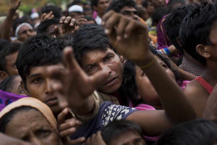 Image: Myanmar's Rohingya ethnic minority refugees reach for food distributed by Bangladeshi volunteers