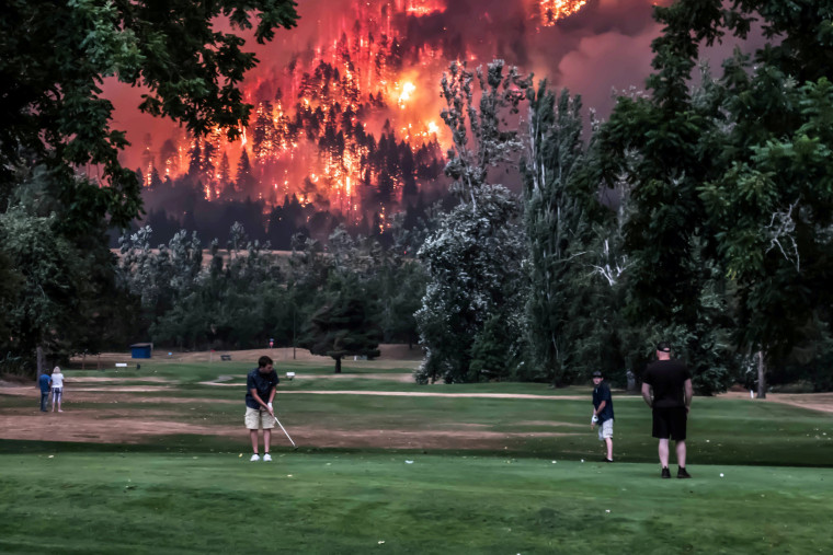 Image: Eagle Creek wildfire burns as golfers play at the Beacon Rock Golf Course in North Bonneville Washington