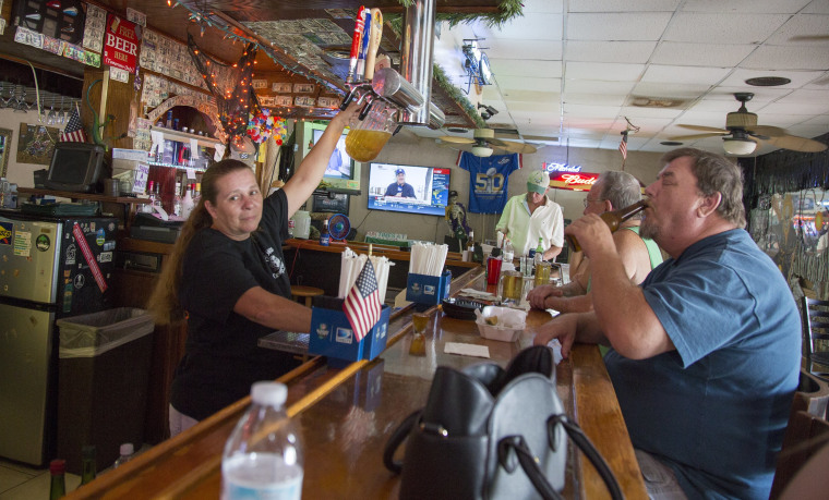 Image: Linda Pauly tops off another pitcher of beer in Gator's Crossroads, a dive bar along U.S. 41 in Collier County, Florida.