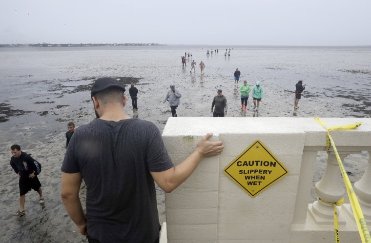 Image: People walk out onto what is normally four feet of water in Old Tampa Bay on Sept. 10. Hurricane Irma and an unusual low tide pushed water out over 100 yards.