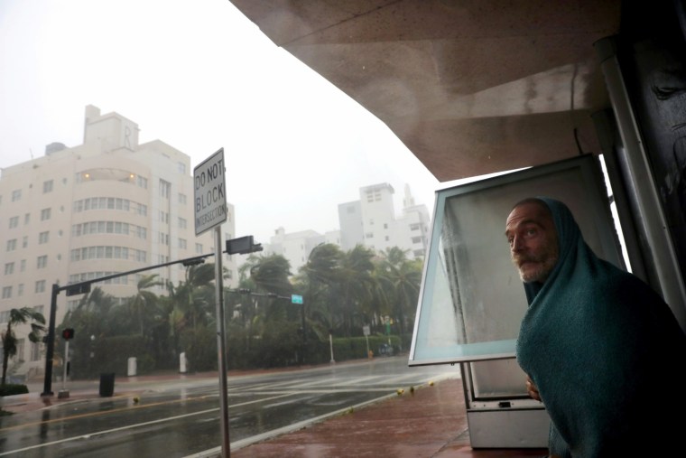 Image: A homeless man takes shelter at a bus stop in Miami Beach on Sept. 10.