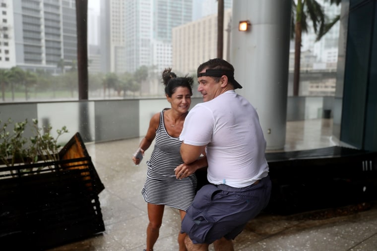 Image: People battle high winds and rain to take in the sights along the Miami River which is flooding as Hurricane Irma passes through on Sept.10.