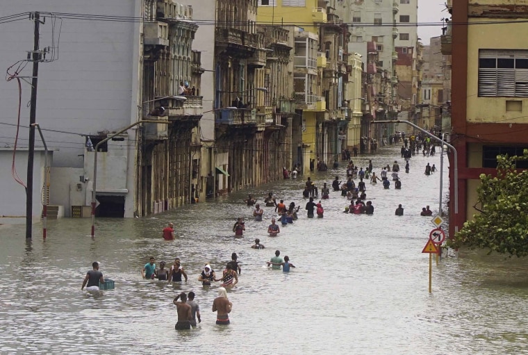 Image: People move through flooded streets in Havana after the passage of Hurricane Irma