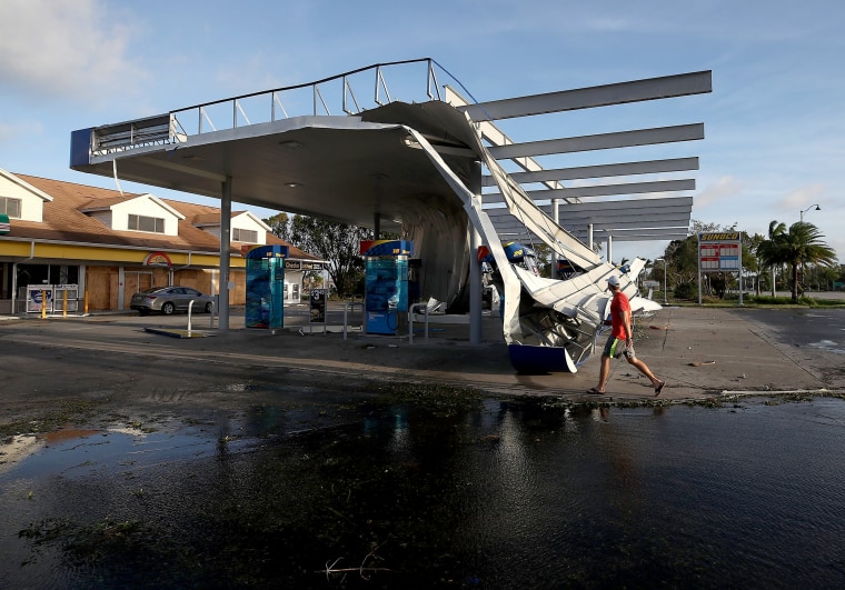 Image: A man looks at the damaged roof of a gas station that succumbed to Irma's winds in Bonita Springs on Sept. 11.