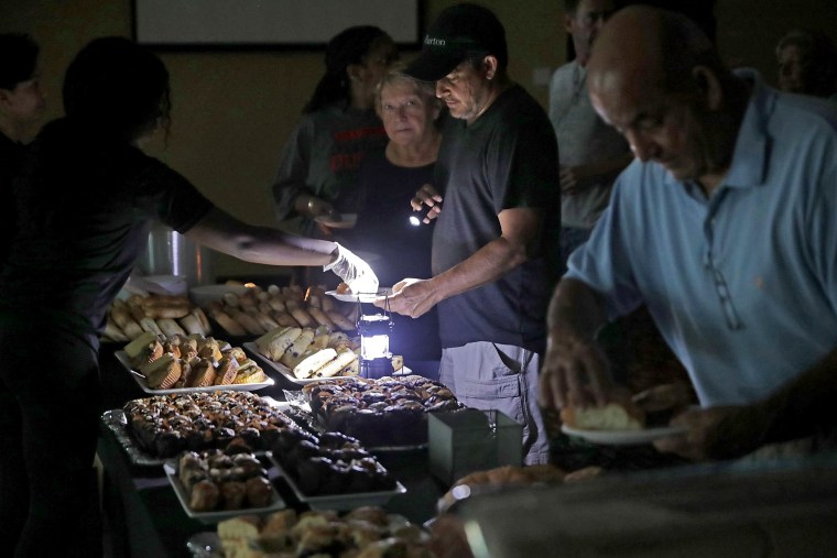 Image: Hotel guests are served breakfast by lamplight as the power remains off at the Courtyard by Marriott in Fort Lauderdale on Sept. 11.