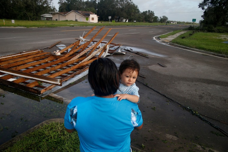 Image: Gonzalo Saldivar and his one year-old son Luke get their first look at the roof that flew off of their home and landed at a nearby intersection in Bowling Green on September 11.