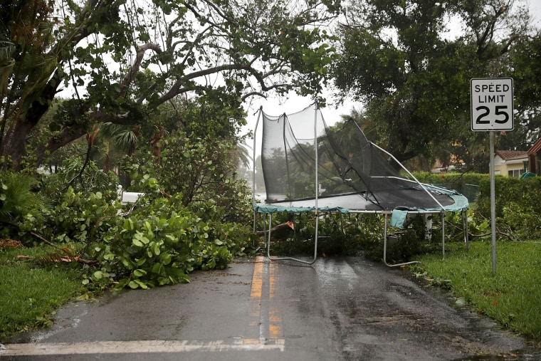 Image: Downed trees and a windblown trampoline block a street in Pompano Beach on Sept.10.