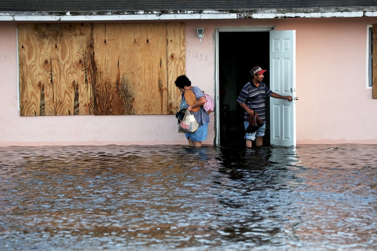 Image: A couple leave their flooded home in Fort Myers the morning after Hurricane Irma swept through the state on Sept. 11, 2017.