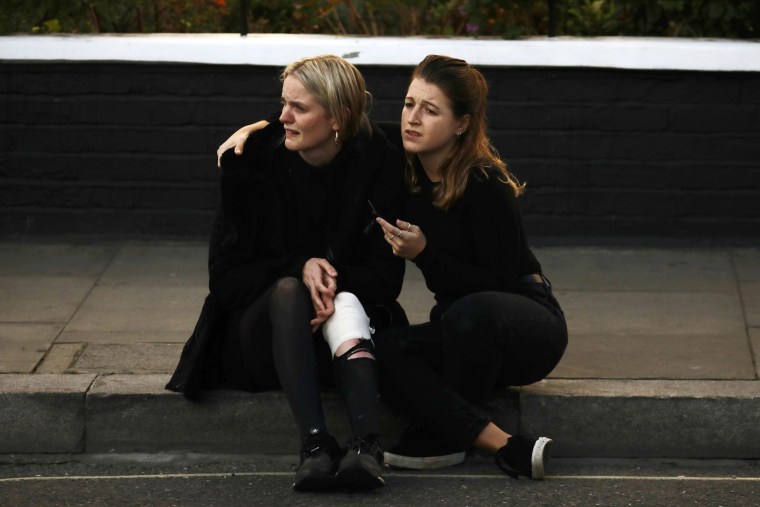Image: An injured woman reacts outside Parsons Green tube station in London