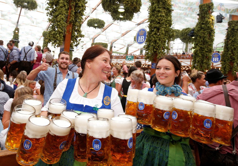 Image: Waitresses carry mugs of beer during the opening day of the 184th Oktoberfest in Munich