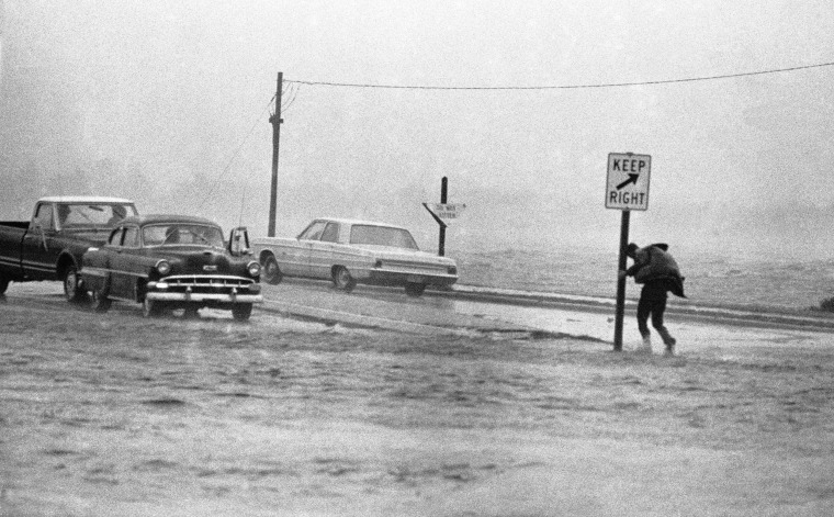 A man clings to road sign in New Bern, North Carolina, during a gust of high wind as Hurricane Ginger approached on Sept. 30, 1971.