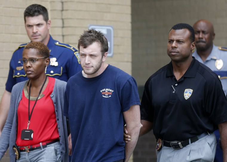Image: Kenneth James Gleason is escorted by police to a waiting police car in Baton Rouge