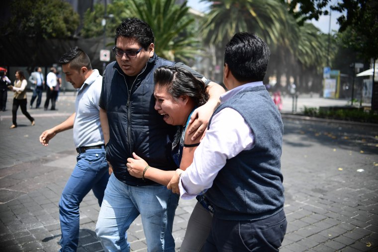 Image: A woman is comforted as an earthquake rattles Mexico City