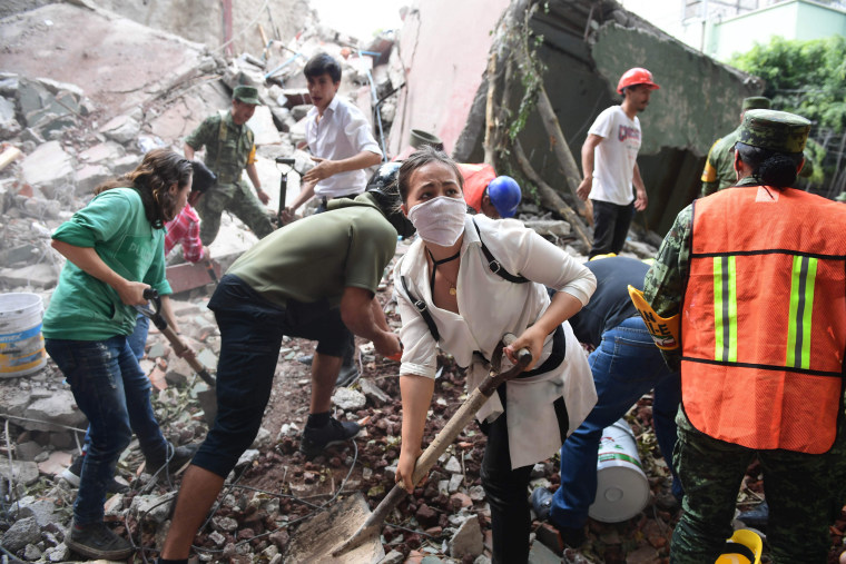 Image: Rescuers remove rubble and debris as they search for survivors in Mexico City