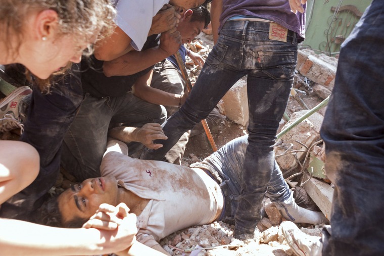 Image: A man is rescued from a collapsed building in Mexico City's Condesa neighborhood