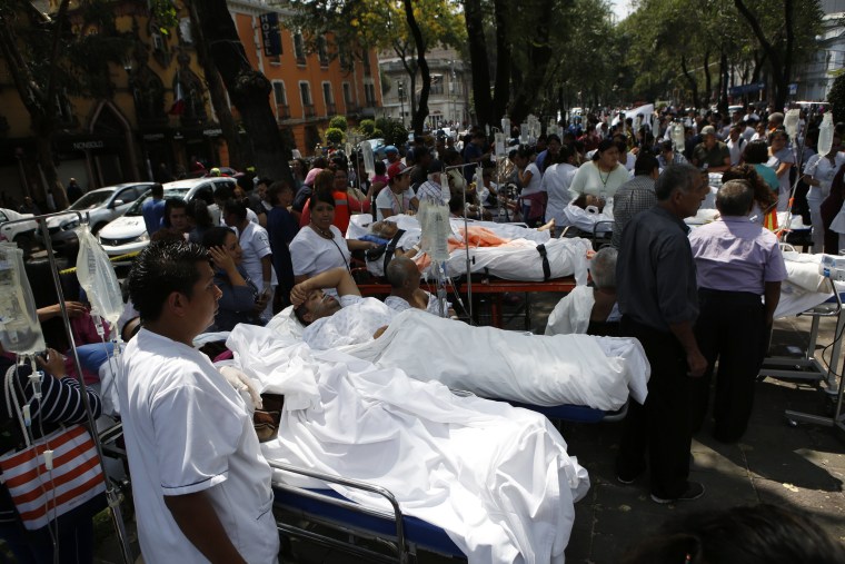 Image: Patients lie on hospital beds after being evacuated following the earthquake
