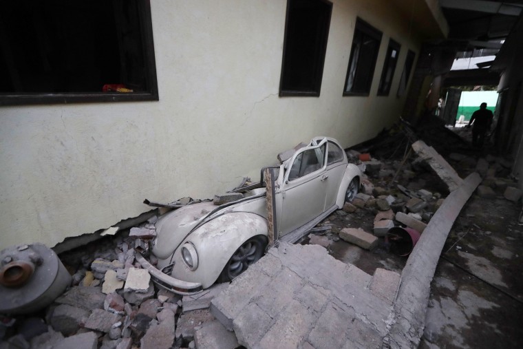 Image: A car sits crushed from a building in Jojutla, Morelos state