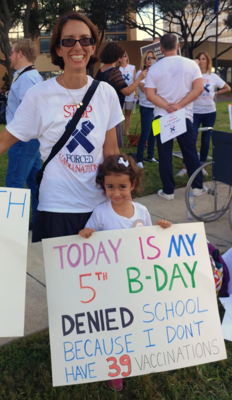 Image: Dene Shulze-Alva and her daughter Sage, 5, protest against vaccine laws in Houston