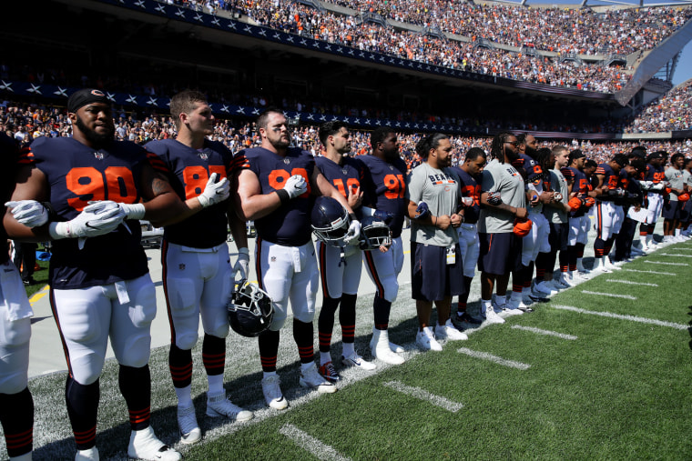 Image: The Chicago Bears lock arms for the national anthem