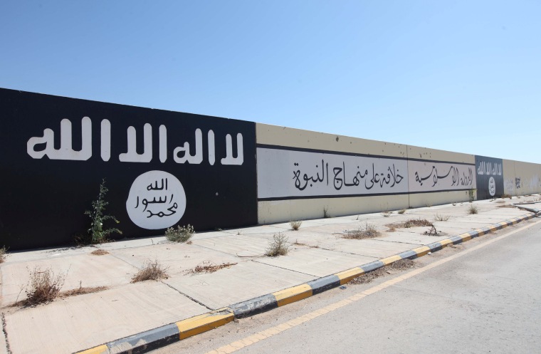 Islamic State painted flags and slogans are seen on a wall after Libyan forces allied with the U.N.-backed government captured Al-Naqa neighborhood, in Sirte