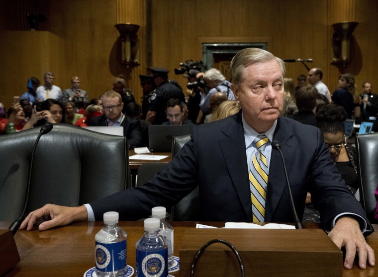 Image: Sen. Lindsey Graham, R-S.C. waits as people in wheelchairs are removed