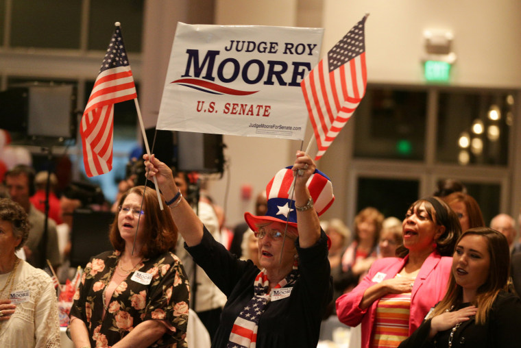 Image: A Republican Moore supporter stands for the national anthem during the runoff election for the Republican nomination for Alabama's U.S. Senate seat in Montgomery