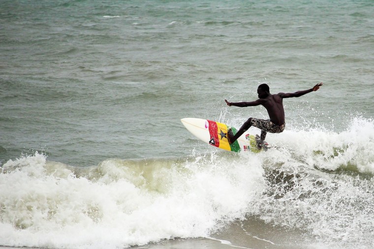 Image: A surfer surfs the ocean swell in Ghana