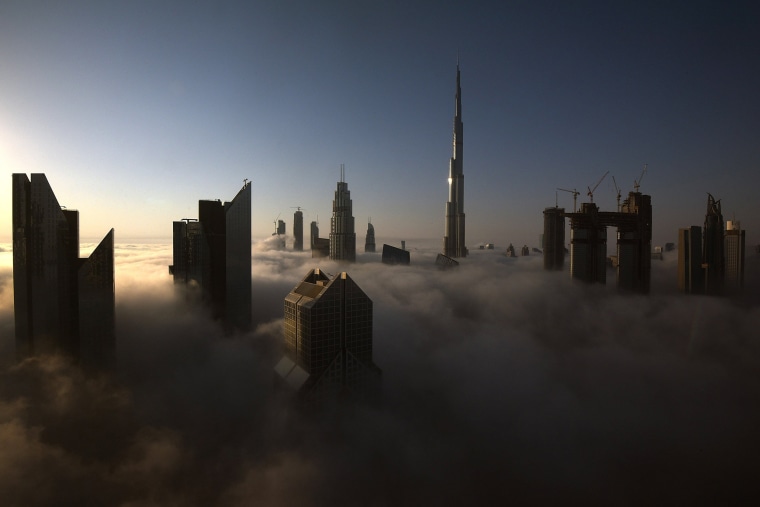 Image: Skyscrapers pierce clouds during a heavy fog in Dubai