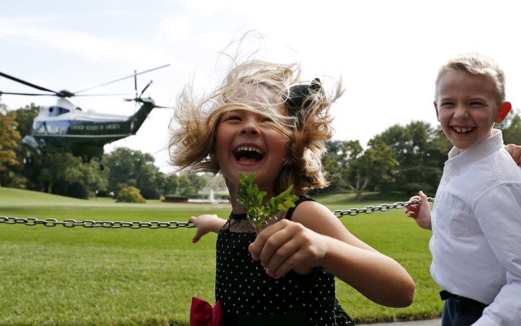 Image: Brooke Fiddes, 5, and her brother Carter Fiddes, 9, both from Charlotte, N.C., react from the rotor wash of Marine One