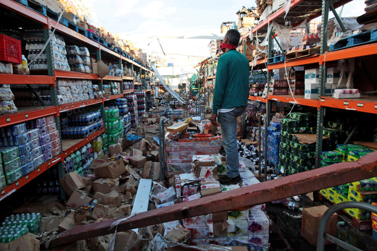 Image: A man stands inside of a destroyed supermarket by Hurricane Maria in Salinas, Puerto Rico