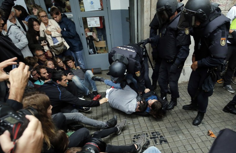 Image: Spanish police hold voters outside a polling station in Barcelona early Sunday as the Catalonia independence poll got underway.