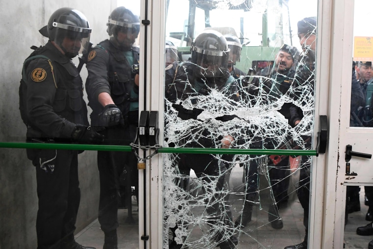 Image: Spanish Guardia Civil guard smash the door of a polling station Catalonia's president was due to vote, early Sunday.