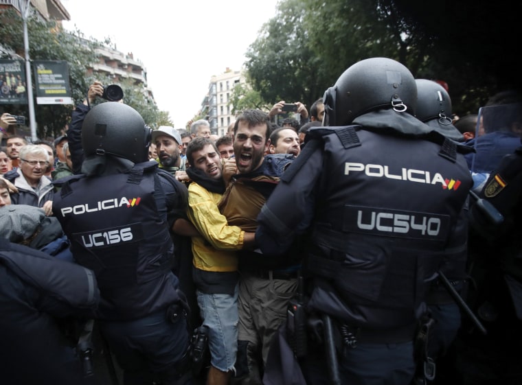 Image: Catalans and police clash outside the Ramon Llull school.