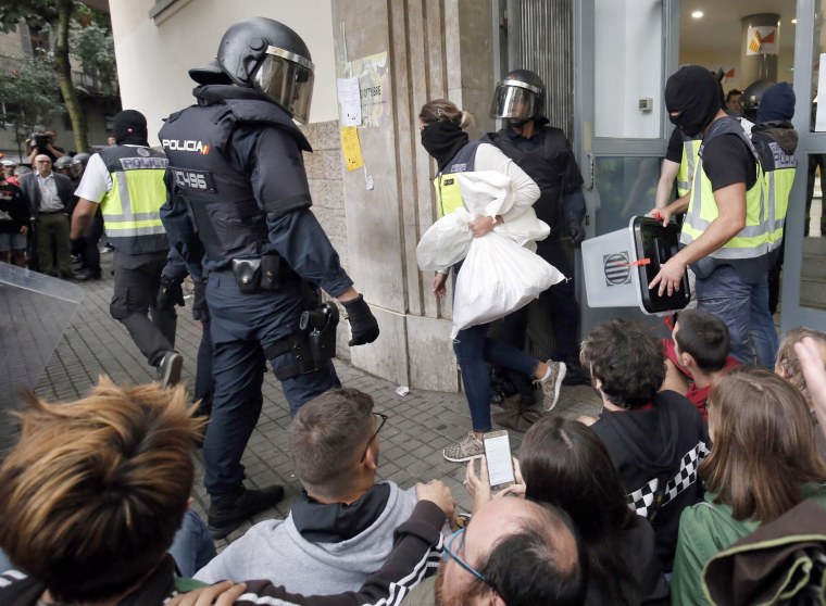 Image: Spanish police seize ballot boxes in a polling station in Barcelona.
