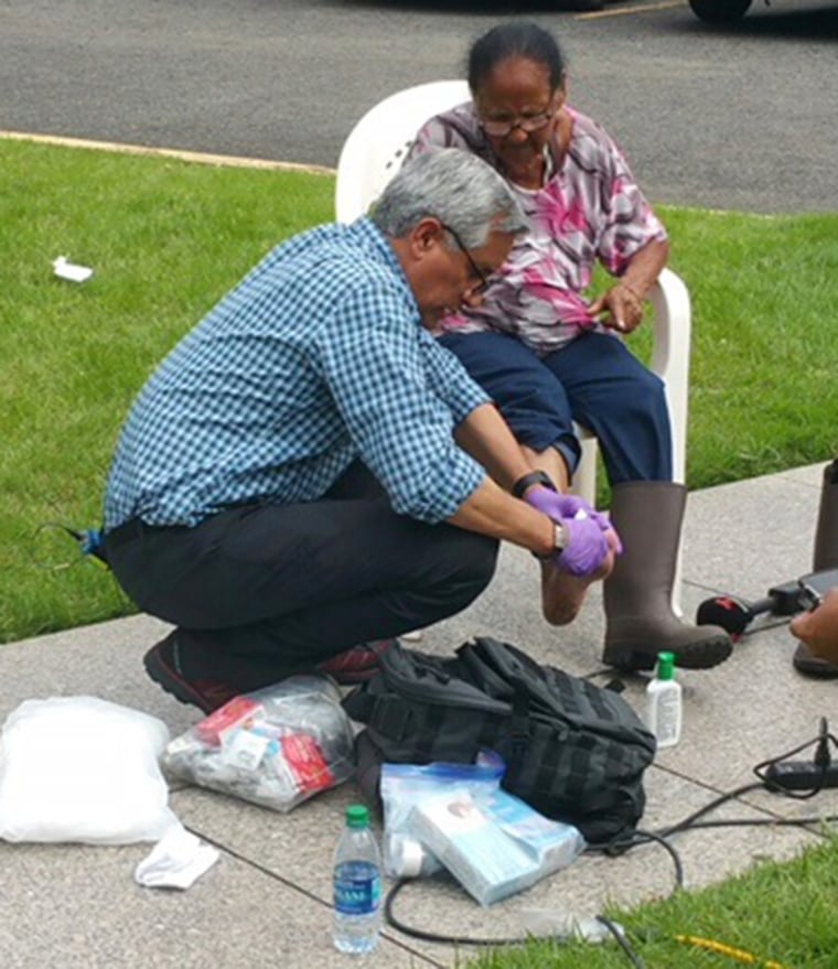 Dr. John Torres, NBC News Medical Corresopondent, treats a wound on Ana Maria Ortiz's foot. The Puerto Rican native has been waiting to see a doctor since Hurricane Maria hit 14 days ago.